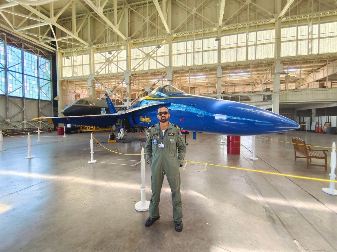 Capt. Guruprasad Kenchappa in flying overalls in an aircraft hangar.